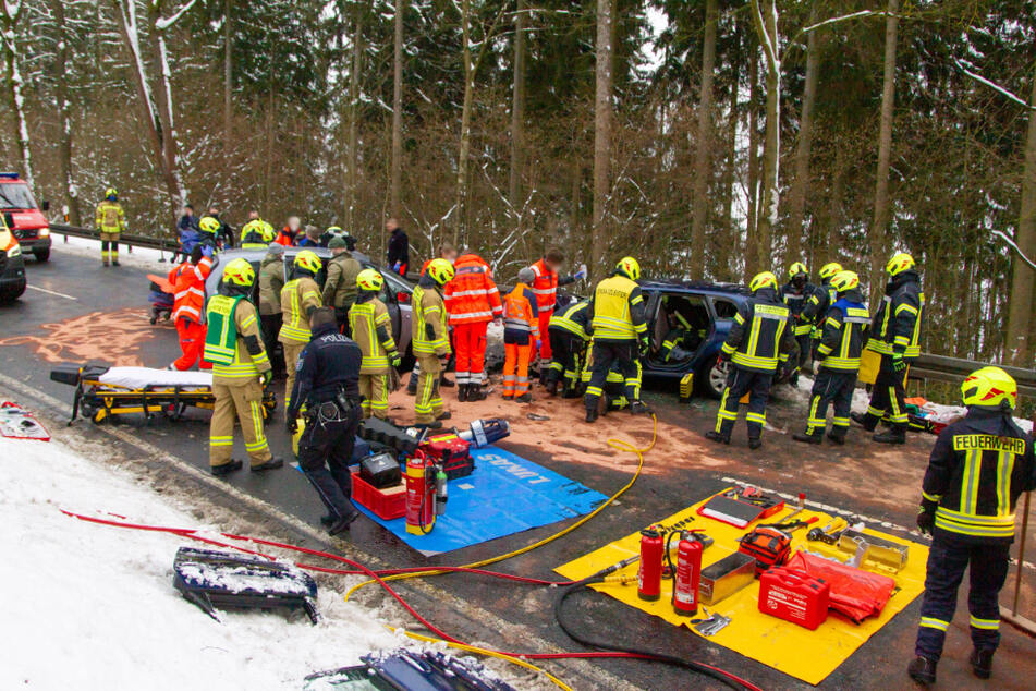 Die Feuerwehr befreit die eingeklemmte Frau aus ihrem Auto.