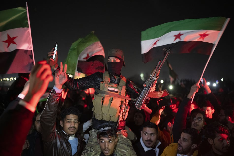 Ein Mitglied der neuen Streitkräfte, ein ehemaliger Rebell, der am Sturz der Regierung von Bashar Assad beteiligt war, feiert während der Silvesterfeierlichkeiten auf dem Umayyad-Platz.