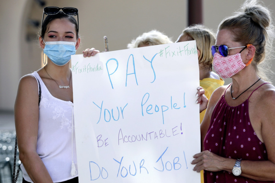 USA, Orlando: Demonstranten mit Masken protestieren gegen Floridas Arbeitslosengeld-System. (Archivbild)