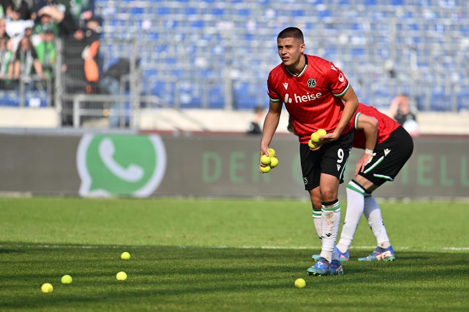 H96-Profi Nicolò Tresoldi (20) beteiligte sich an den Aufräumarbeiten, nachdem zahlreiche Tennisbälle auf den Platz geflogen waren.