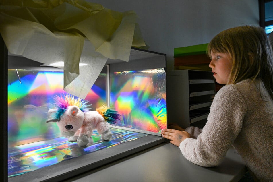 Lia (6) beobachtet, wie ihr rosa Einhorn den Röntgenscanner durchläuft.