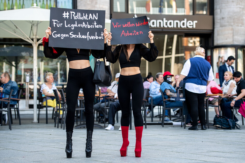 Sexarbeiterinnen halten während einer Demonstration in Köln Schilder in die Höhe.