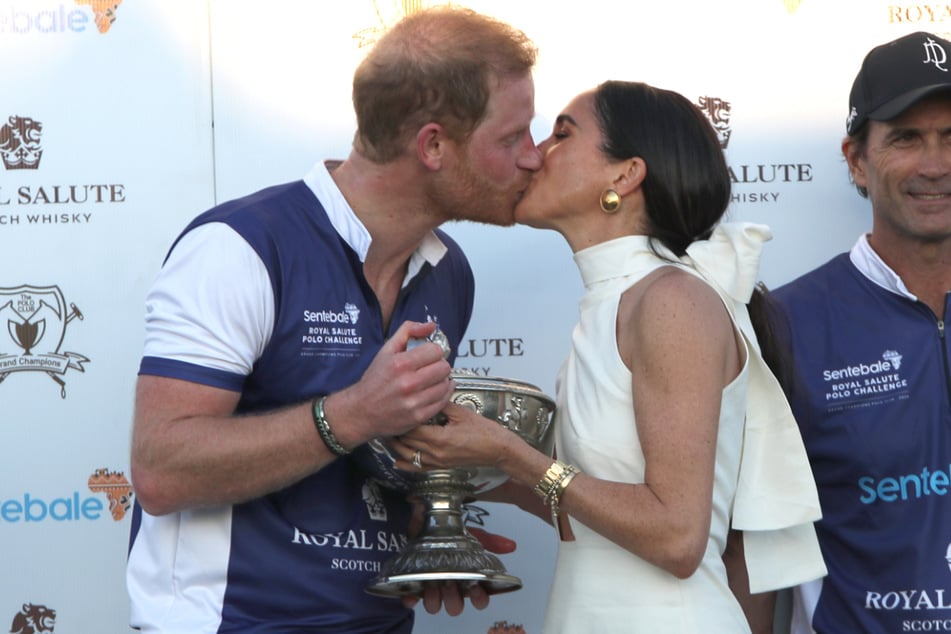 Duchess Meghan (r.) and Prince Harry shared a ssweet kiss on Friday captured by photographers.