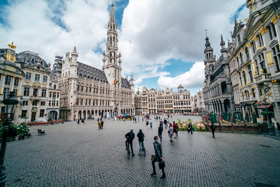 Touristen und Passanten sind auf dem Grand-Place, den zentralen Platz von Brüssel, unterwegs.