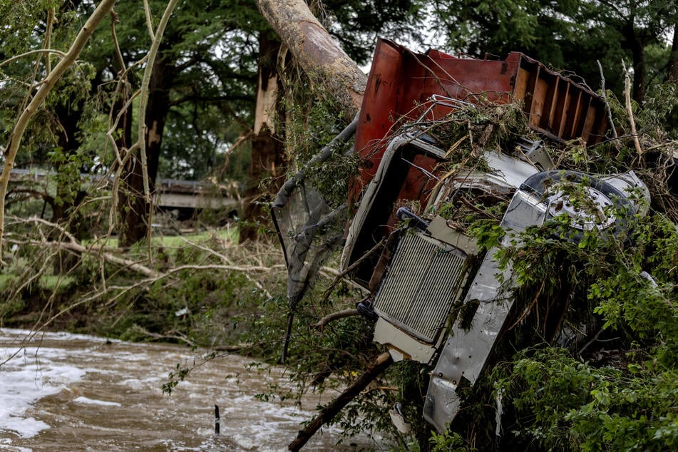 A large truck is impaled onto a tree after flash flooding on the bank Guadalupe River on Saturday in Center Point, Texas.