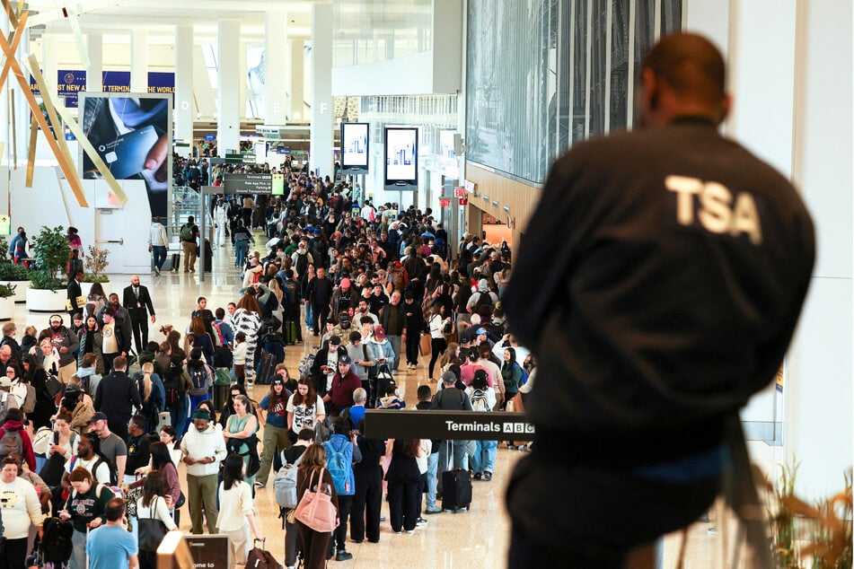 A TSA agent looks on passengers wait to go through security at New York's LaGuardia airport on March 22, 2026.