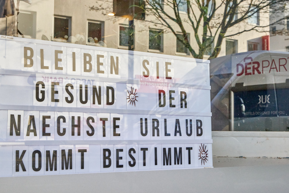 Eine Tafel mit der Aufschrift: "Bleiben Sie gesund. Der nächste Urlaub kommt bestimmt" steht im Schaufenster eines DER-Reisbüros in Hamburg-Eimsbüttel.