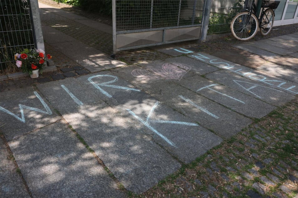 "Wir lieben unsere Kita", steht in Kreide geschrieben vor dem Eingang des Gebäudes. Auch ein Strauß mit Blumen steht vor dem Tor.