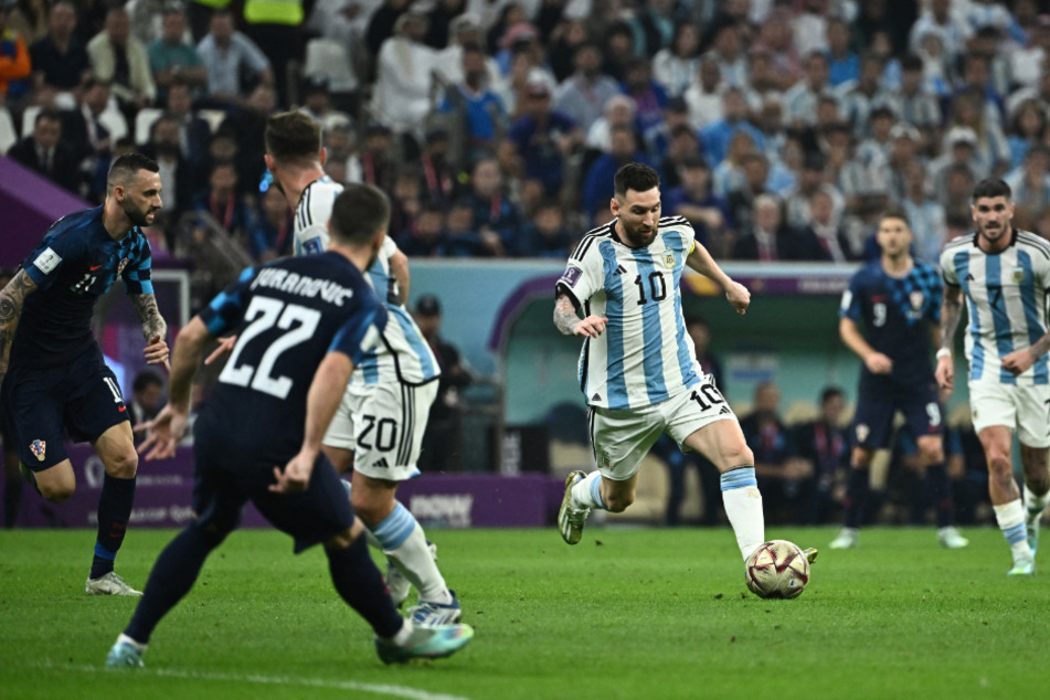 Lionel Messi (M.) dribbelt sich durch die kroatischen Reihen.