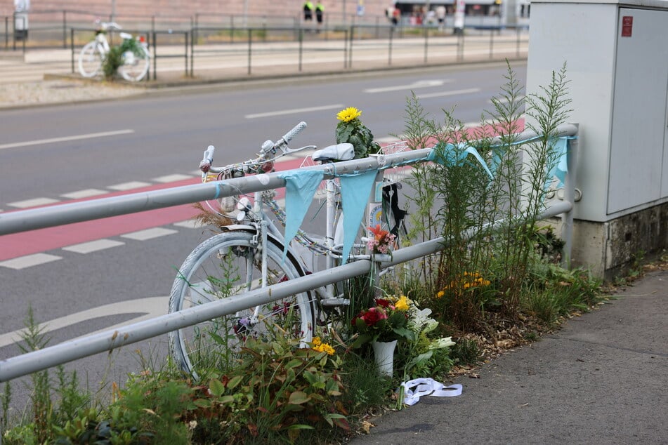 Familie und Freunde haben an einem Geländer auf Höhe des Unglücksorts Blumen gepflanzt.