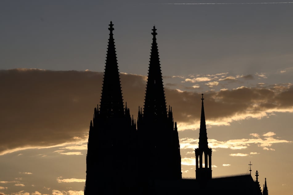 Die Silhouette des Kölner Doms vor der untergehenden Sonne.