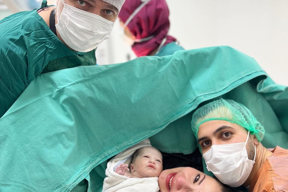 Gynäkologe Eray Balcan zusammen mit den glücklichen Eltern nach der Geburt ihres Sohnes.