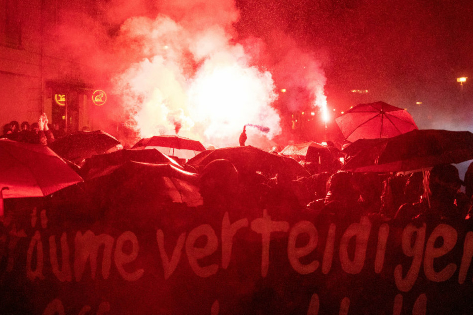 Demonstranten zünden bei einer Demonstration Bengalische Feuer.