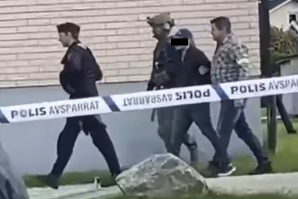Hier führt die Polizei den Verdächtigen ab.