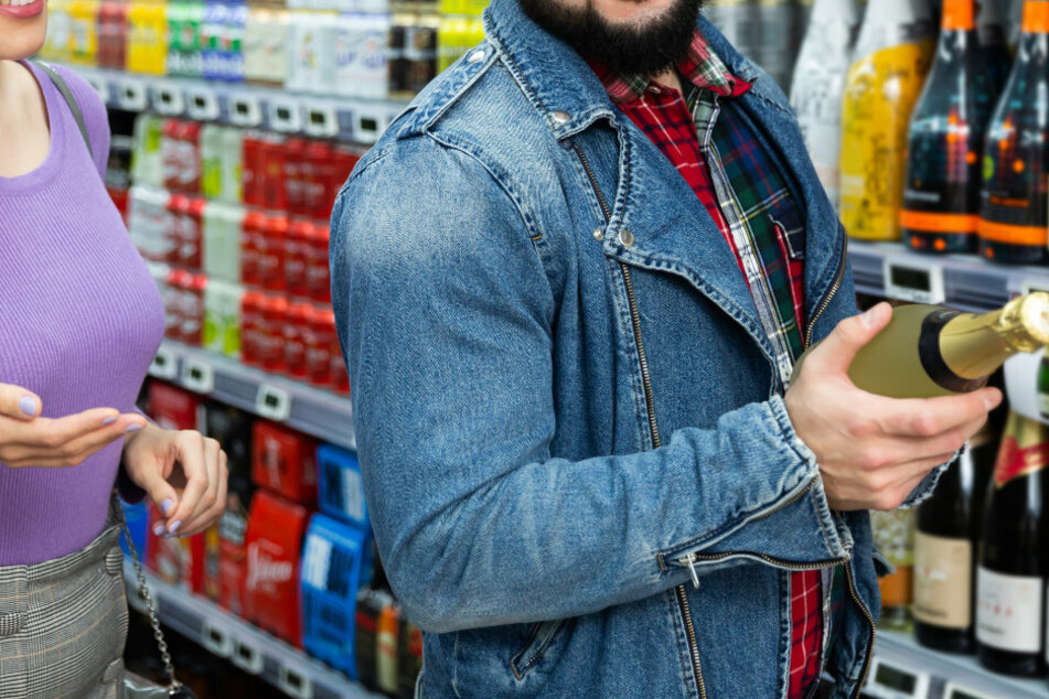 Kunden stehen in einem Supermarkt vor einem Regal mit Sekt und Champagner. (Symbolbild)