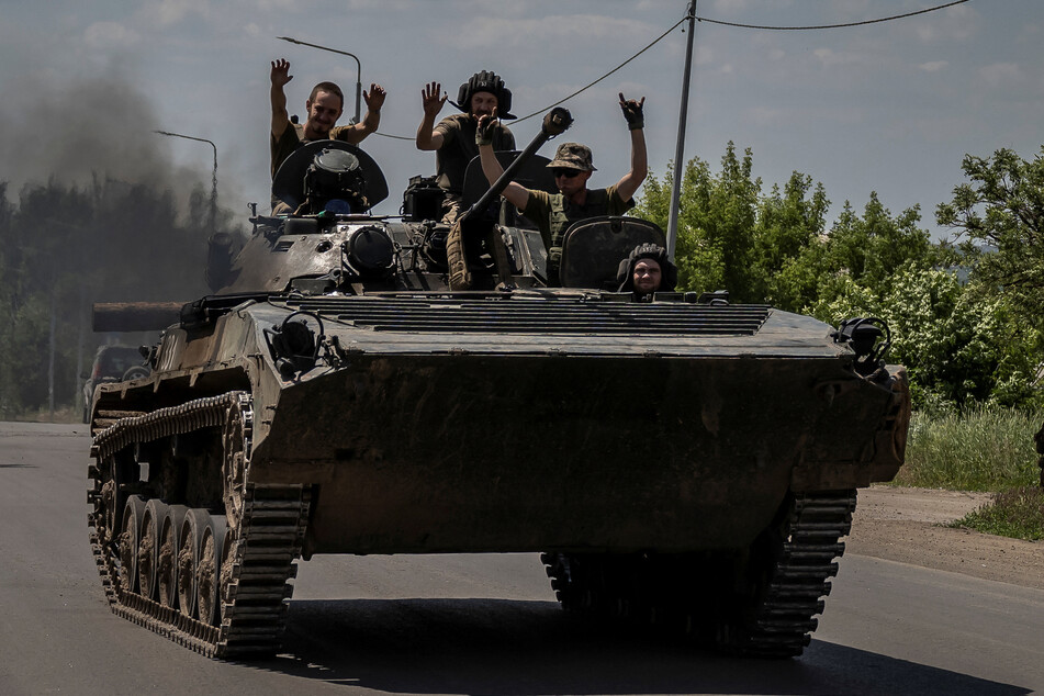Ukrainian troops ride a tank near the city of Bakhmut as a major counteroffensive against Russian forces proceeds.