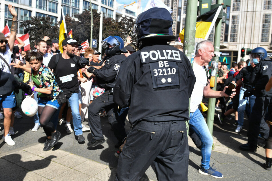 Teilnehmer einer Demonstration gegen die Corona-Maßnahmen durchbrechen eine Polizeikette an der Ecke Friedrichstraße/Reinhardtstraße