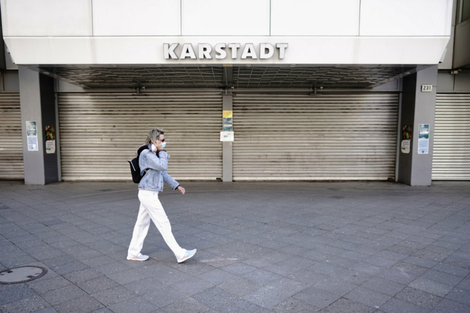 Eine Passantin mit Mund-Nasenschutz geht am Mittag am Kurfürstendamm an einer geschlossenen Karstadt-Filiale vorbei.