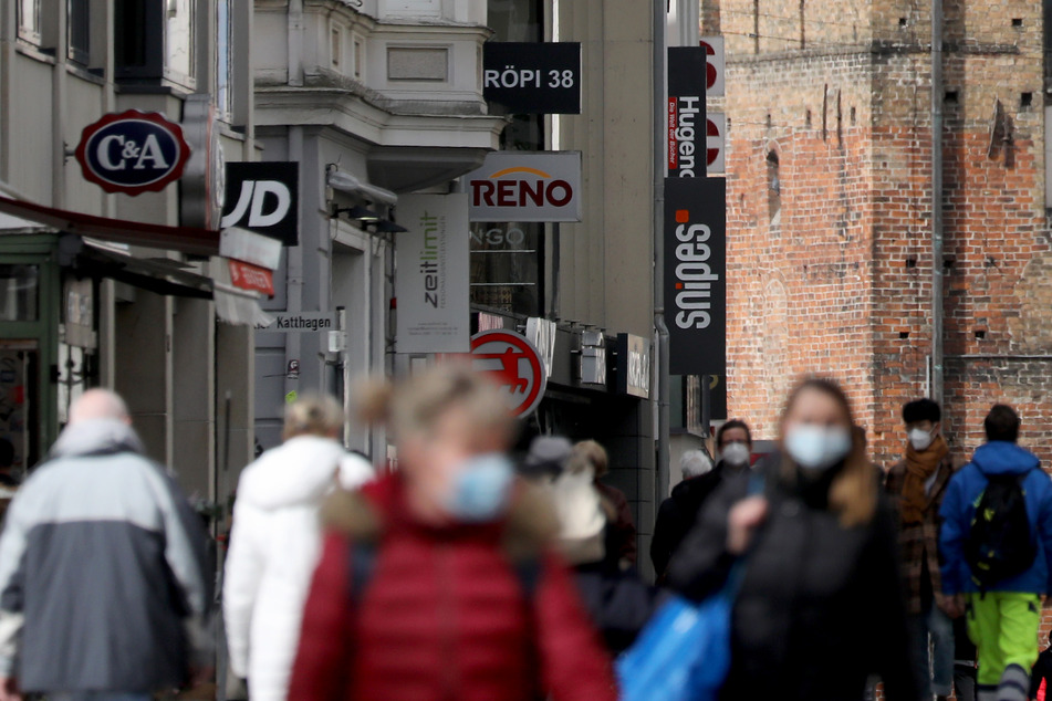 Passanten sind auf dem Boulevard vor dem Kröpeliner Tor unterwegs. In der Innenstadt besteht Maskenpflicht.