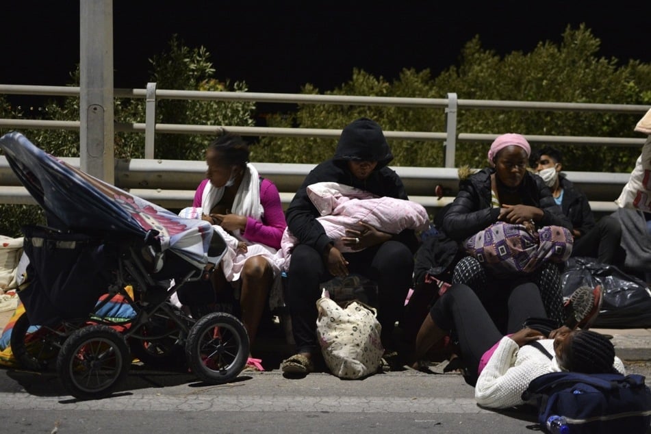 Geflüchtete sitzen auf einer Brücke, während im Flüchtlingslager Moria auf Lesbos ein Feuer brennt. Hamburg hat bisher 270 Flüchtlinge aus griechischen Lagern aufgenommen. (Archivfoto)