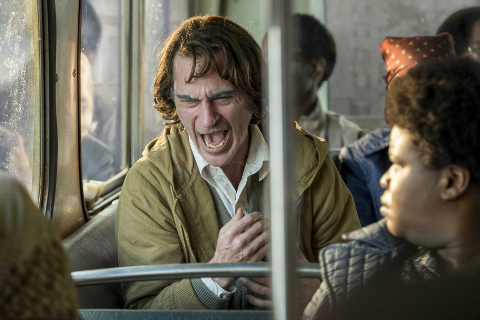 Arthur Fleck aka der Joker sorgt in einer Filmszene für Unruhe in einem Bus.