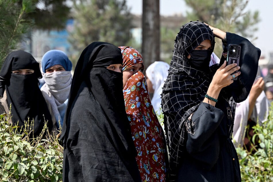 Eine afghanische Frau filmt auf einer Straße in Kandahar die Feierlichkeiten zum fünften Jahrestag.