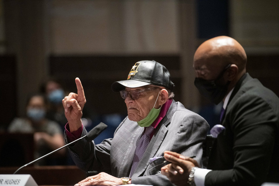 Hughes Van Ellis (l.), Tulsa Race Massacre survivor and World War II veteran, is joined by attorney Damario Solomon-Simmons as he shares his testimony during a House subcommittee hearing.