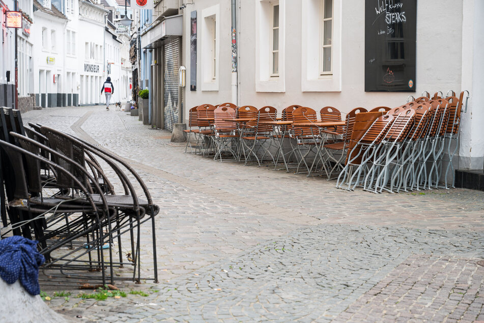 In der Innenstadt von Saarbrücken stehen im Außenbereich einer Gastronomie Stühle. Am heutigen Dienstag darf die Außengastronomie unter Auflagen wieder öffnen.