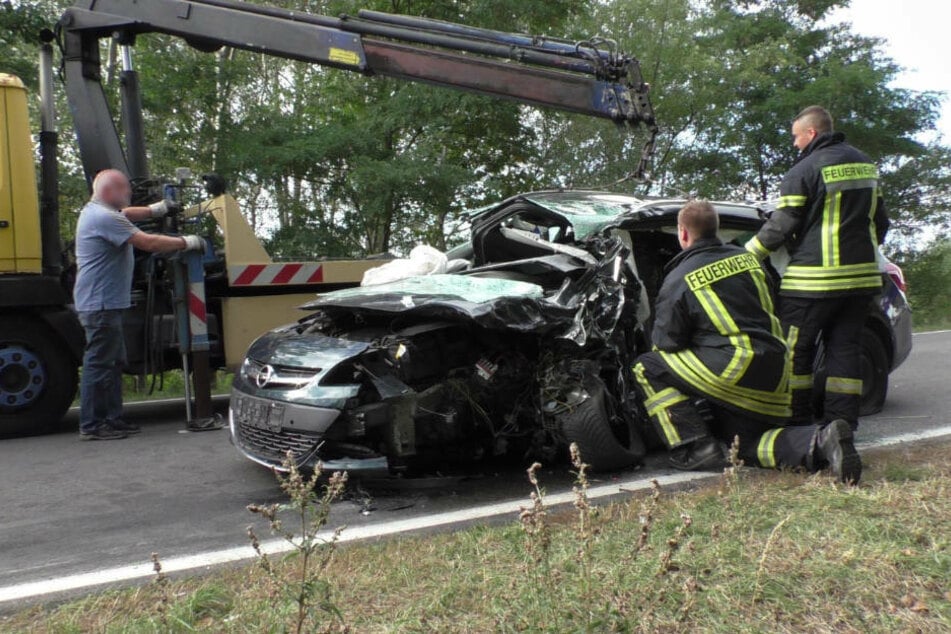 Zwei Feuerwehrmänner sichern das Opel-Wrack, das von einem Abschleppwagen entfernt werden musste.