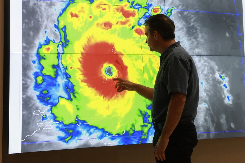 John Cangialosi, Senior Hurricane Specialist at the National Hurricane Center, inspects a satellite image of Hurricane Beryl, the first hurricane of the 2024 season, at the National Hurricane Center on Monday in Miami, Florida.