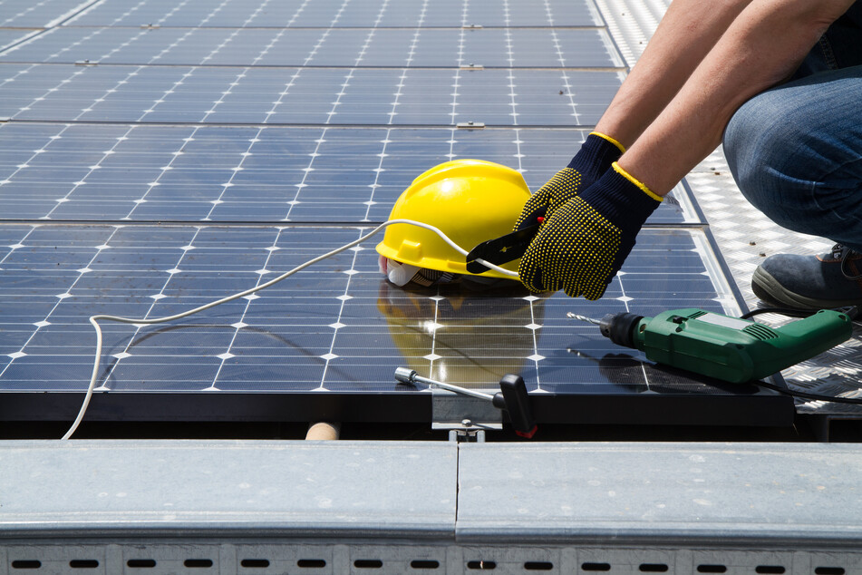 Arbeiter schraubt Solarzellen auf Dach, da passiert ein schlimmes Unglück
