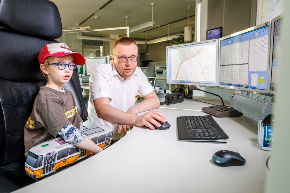 Disponent Sven Wierick (49) erklärt dem Jungen das Streckennetz am Computer.