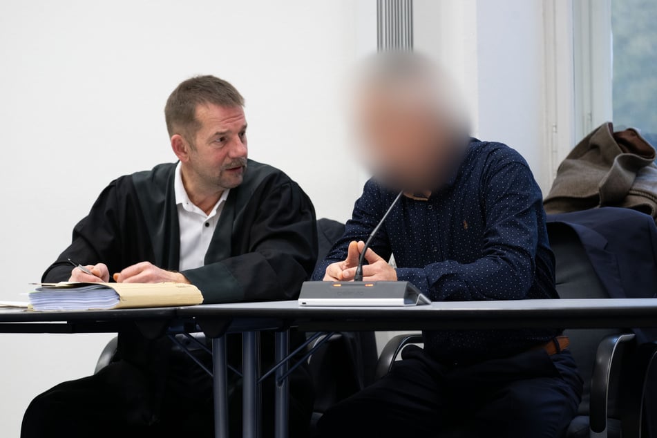 Der Angeklagte (r.) unterhält sich vor dem Beginn der Verhandlung mit seinem Verteidiger.