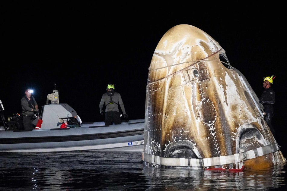 In this NASA handout, Support teams work around the SpaceX Dragon Endeavour spacecraft shortly after it landed with NASA astronauts Matthew Dominick, Michael Barratt, and Jeanette Epps, and Roscosmos cosmonaut Alexander Grebenkin in the Gulf of Mexico off the coast of Pensacola, Florida on Friday.