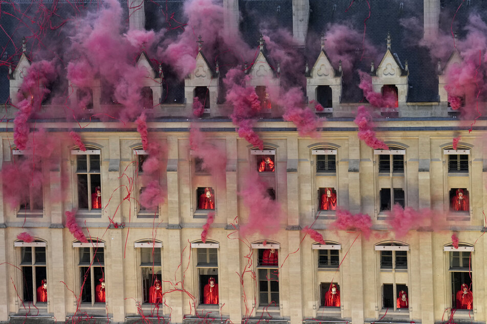 Smoke billows near windows as performers depicting the 18th century Queen Marie Antoinette participate and Metal band Gojira and opera singer Marina Viotti play, in the opening ceremony of the Paris 2024 Olympic Games in Paris on July 26, 2024.