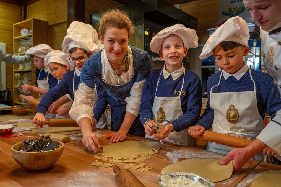 Kruzianer aus der vierten Kasse backen mit dem Stollenmädchen die ersten Plätzchen in der Striezelmarkt-Backstube.