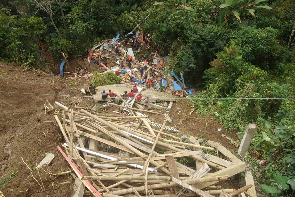 Rettungskräfte suchen in einem Dorf im Bezirk Tana Toraja nach Überlebenden.