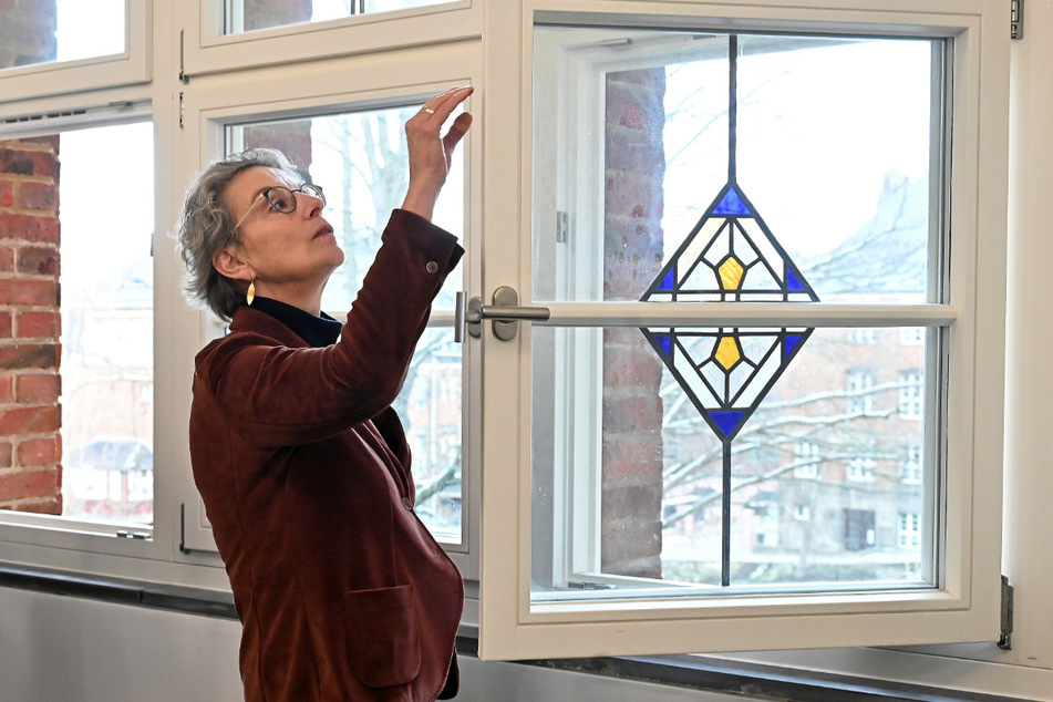 Rektorin Staudinger begutachtet die historischen Fenster, die aus energetischen Gründen um eine weitere Scheibe ergänzt worden.