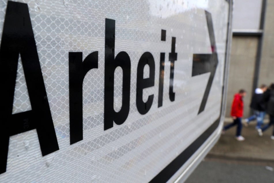 Menschen gehen an einem Schild der Agentur für Arbeit vorbei. (Symbolbild)