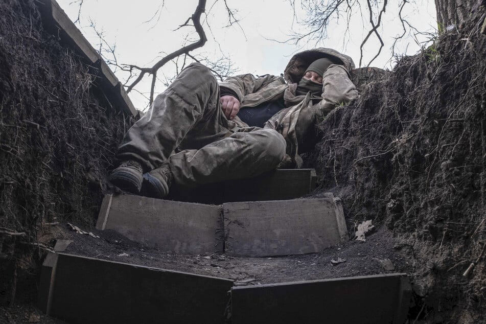 Ein ukrainischer Soldat ruht sich in einem Schützengraben an der Frontlinie in der Nähe von Lyman aus. (Archivbild)