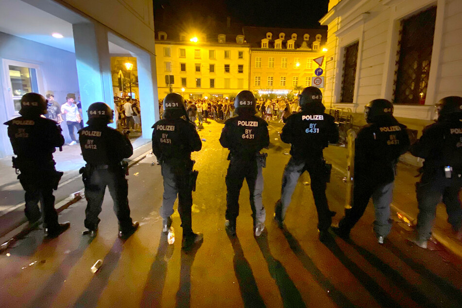 Polizisten stehen in der Augsburger Innenstadt, wo sich Menschen zum Feiern versammelt haben. Bei Räumungen eskalierte die Lage.