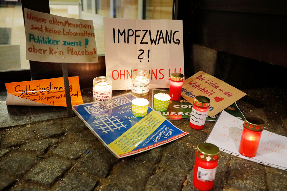 Impfgegner und Corona-Leugner stellten Kerzen und Plakate auf.