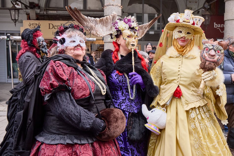 Verkleidete Besucher stehen während des Venezianischen Maskenzaubers in den Colonnaden.