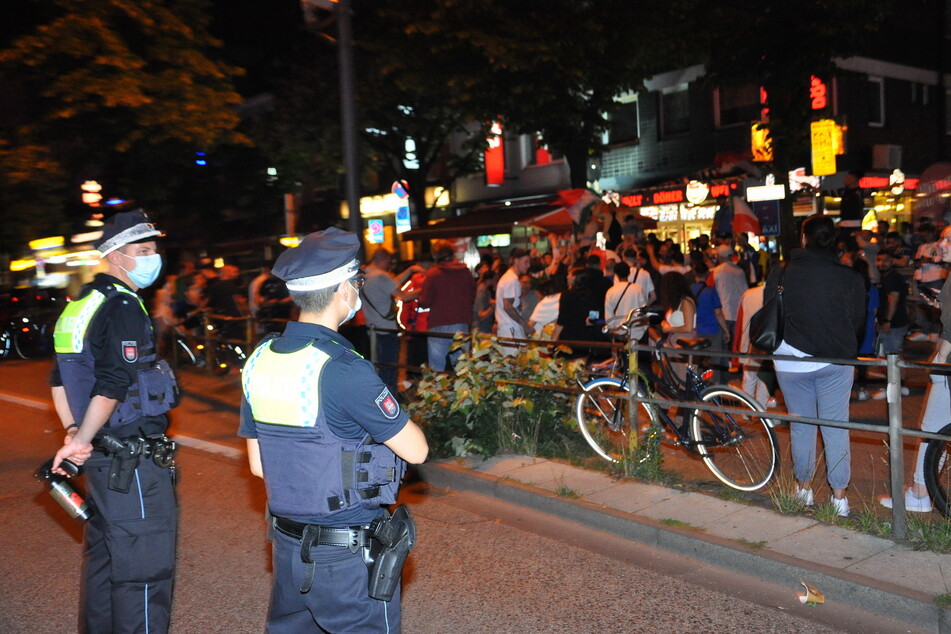 Zwei Beamte der Polizei beobachten das Geschehen auf der Hamburger Reeperbahn. Einige Hundert Menschen feierten dort den EM-Sieg der Italiener.