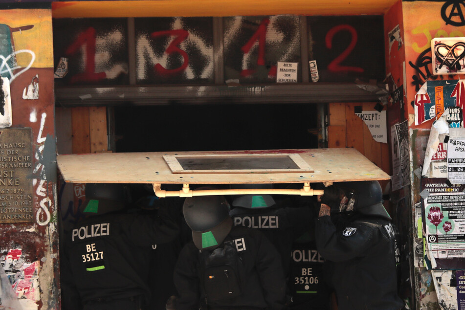 Mit schweren Geräten verschaffen sich die Polizisten gewaltsam Zutritt zu dem verbarrikadierten Haus.