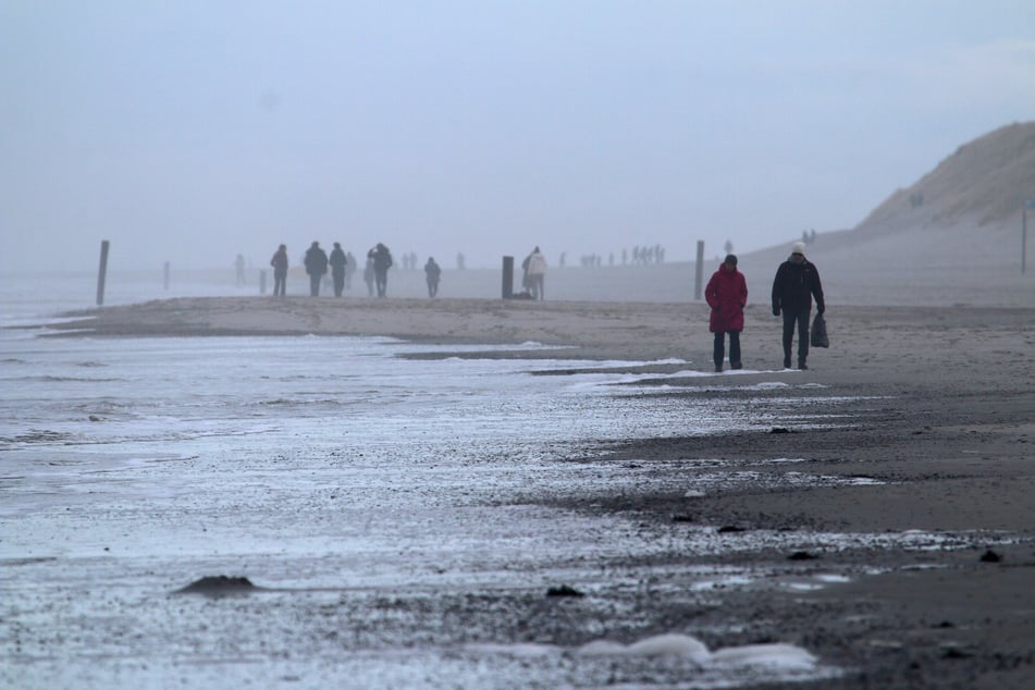 Spaziergänger sind am Weststrand der Nordsee-Insel unterwegs.