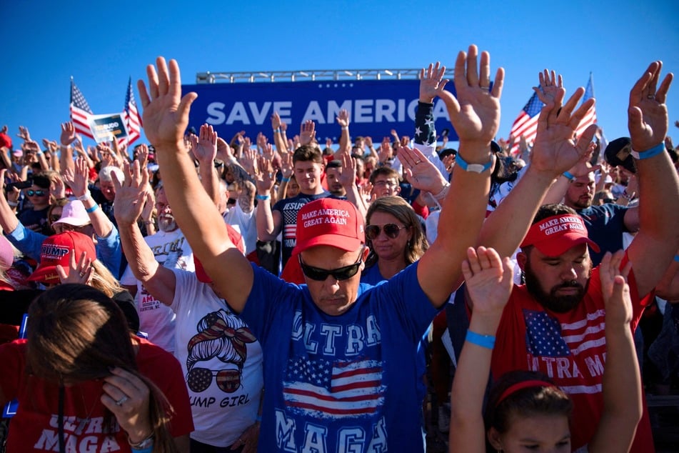 MAGA fans pray before a Save America rally for Donald Trump at the Aero Center Wilmington on September 23, 2022 in Wilmington, North Carolina.