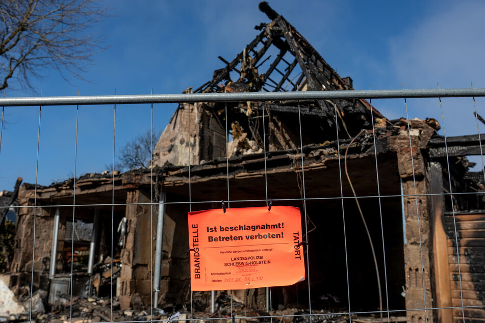 Ein Hinweisschild mit der Aufschrift "Ist beschlagnahmt. Betreten verboten" der Landespolizei hängt an einem Zaun vor den Überresten des bei der Explosion nahezu vollständig zerstörten Reihenendhauses.