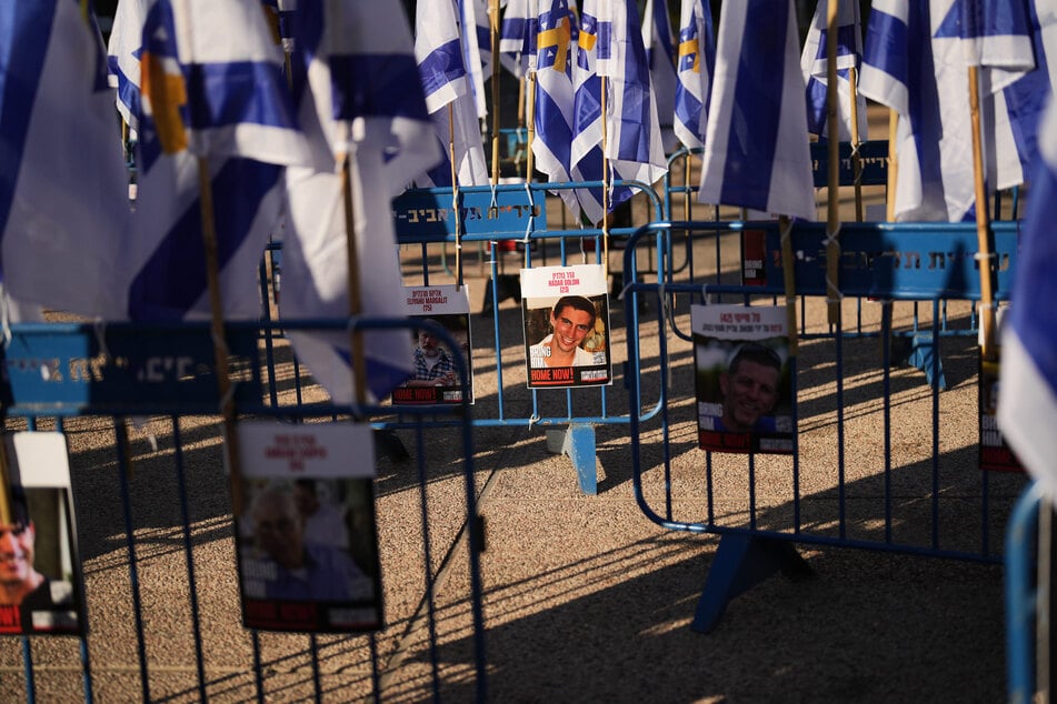 Israelische Flaggen und Fotos von Geiseln stehen auf dem Platz der Geiseln.