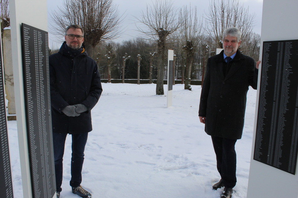 Sven Riesel (l.), Kommissarischer Stiftungsgeschäftsführer, und der Großschwednitzer Bürgermeister Jons Anders, stehen vor den Gedenkstelen mit den Namen der Euthanasie-Opfer.